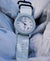 Cerakote Snow White field timer watch with a Multicam Alpine white camouflage-patterned strap.
