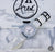 Close-up of a Cerakote Snow White Field-1 timer watch featuring a lumed ARES arrow crown on a Multicam Alpine white camouflage-patterned strap.